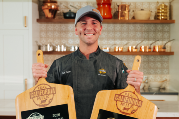 Professional food industry winner holding Real California branded cutting boards, representing excellence in foodservice supply and wholesale distribu