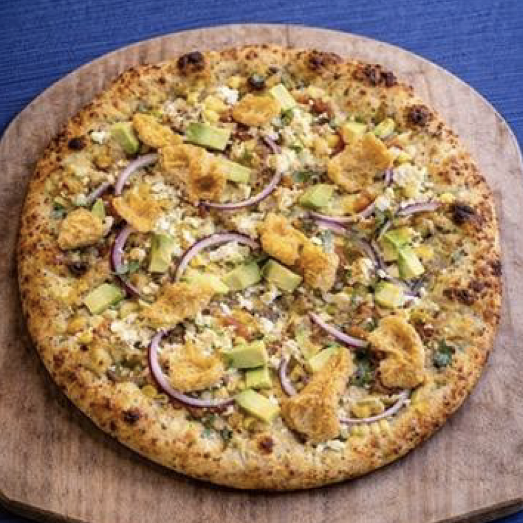 Artisan pizza topped with seasoned chicken pieces, fresh avocado chunks, thinly sliced red onion, and melted cheese on a whole grain crust.