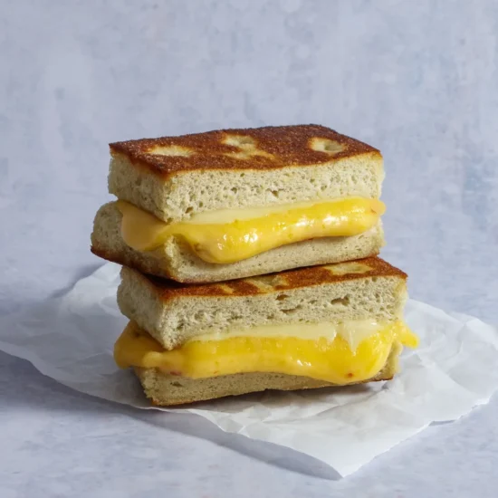 Golden-brown toasted focaccia bread sandwich with melted cheese and scrambled eggs, ideal for foodservice and wholesale food suppliers.