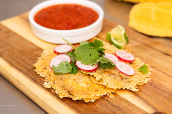 Crispy tortillas topped with fresh garnishes and served with tangy salsa and lime.