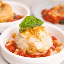 Cheesy dumplings served in tomato sauce, garnished with fresh basil for a delightful taste.