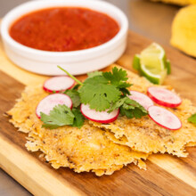 Crispy tortillas topped with fresh garnishes and served with tangy salsa and lime.