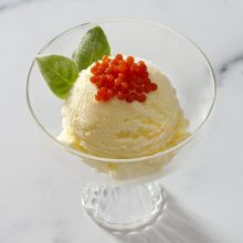 Ice cream topped with caviar in an elegant glass bowl, a unique dessert fusion.