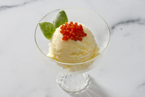 Ice cream topped with caviar in an elegant glass bowl, a unique dessert fusion.